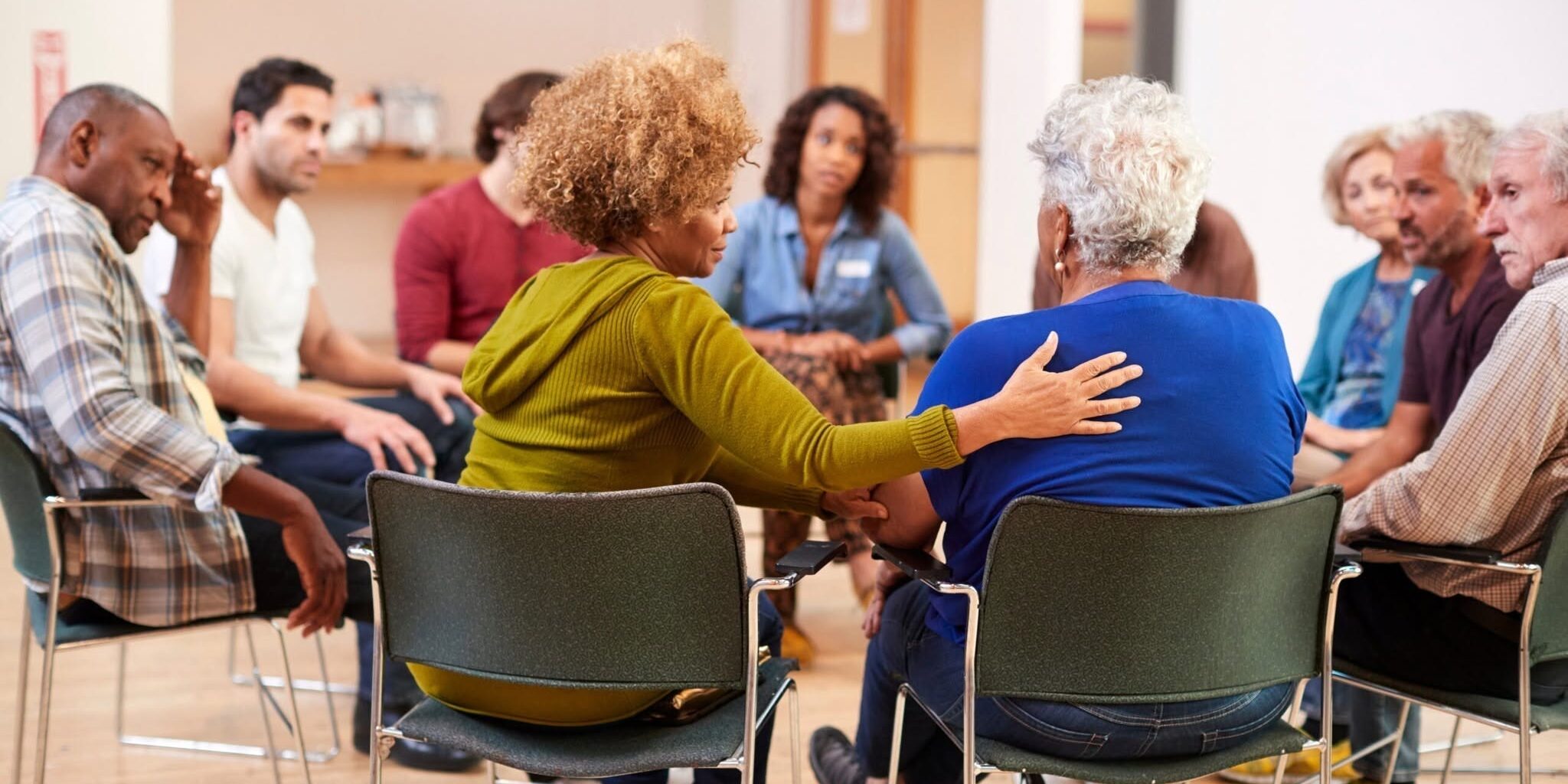 caregiver-support-group-meeting Caregiver support group sitting in a circle offering comfort