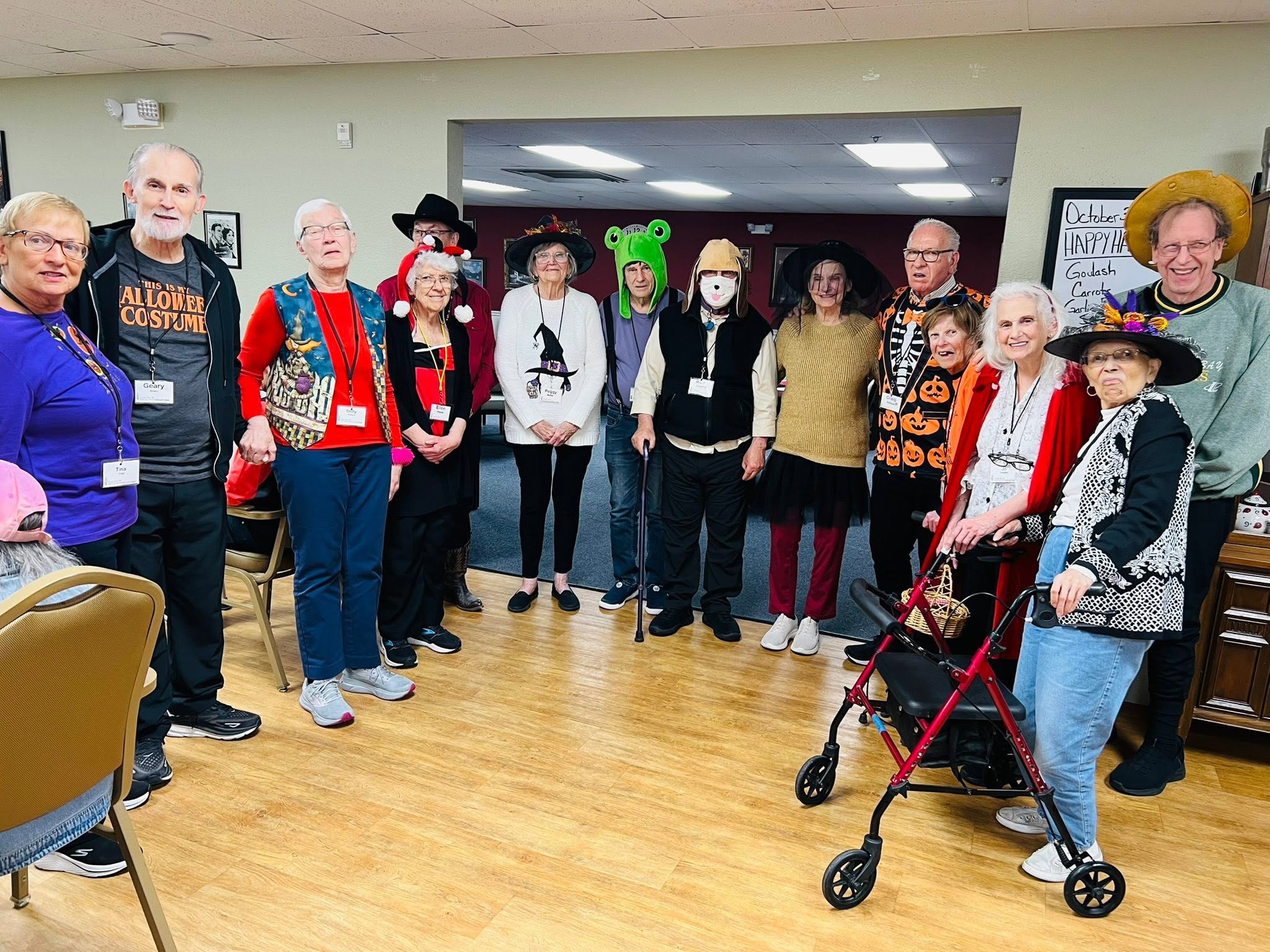 Seniors and staff in Halloween costumes at adult day services center